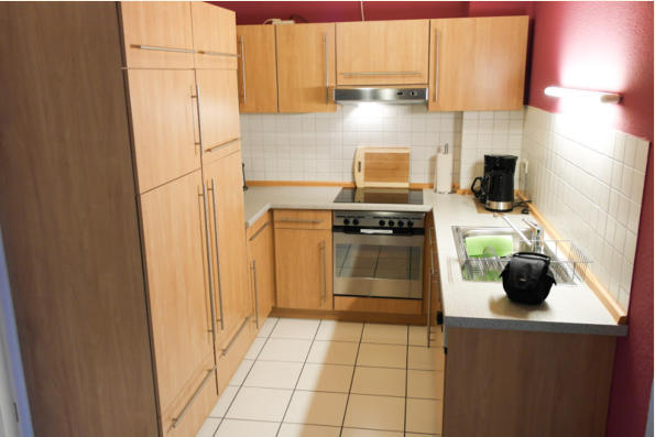 Küche mit Echtholzfurnier. Hochwertiger Ausführung speziell für undere Gäste. Mikrowelle, Radio, Kühlschrank und Herd runden die Ausstattung ab.
